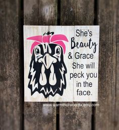 a wooden sign that says she's beauty and grace she will peck you in the face