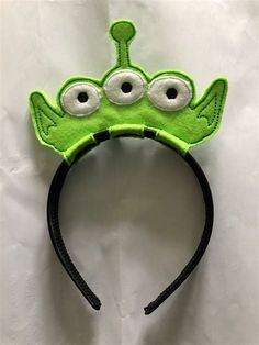 a green headband with googly eyes on it