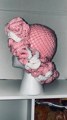 a crocheted pink hat on top of a white mannequin head