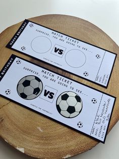 two soccer tickets sitting on top of a wooden plate