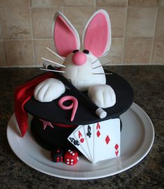 a cake that is shaped like a rabbit with playing cards on the plate next to it