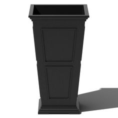 a tall black planter sitting on top of a white floor next to a shadow