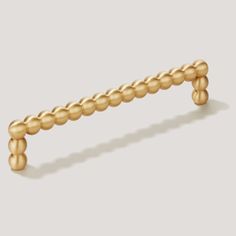 a gold beaded handle on a white background