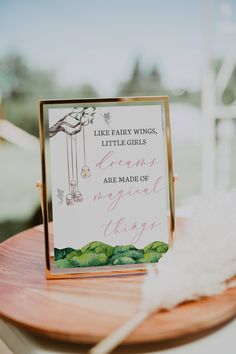 a close up of a sign on a table near a white bird and some feathers