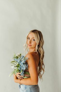 a beautiful blonde woman holding a bouquet of flowers