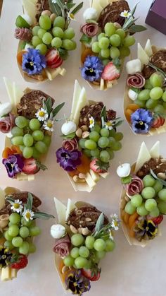 there are many small cupcakes decorated with grapes and flowers