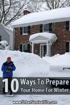 a man standing in front of a house covered in snow