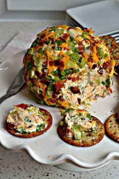 an appetizer with crackers and cheese on a plate next to a fork