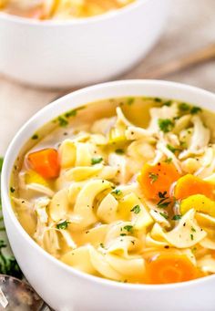 two white bowls filled with chicken noodle soup