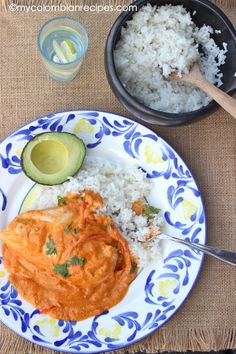 a plate with rice, avocado and some kind of sauce on it next to other dishes