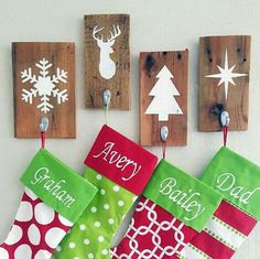 christmas stockings hung on the wall with wooden signs hanging from it's hooks and decorations