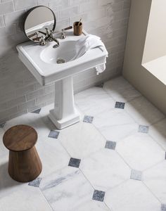 a white sink sitting next to a mirror on top of a bathroom wall mounted faucet