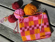 two balls of yarn sitting on top of a wooden bench