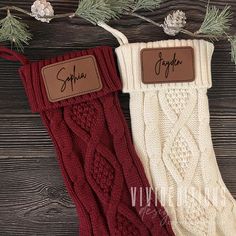 two pairs of red and white knitted stockings with name tags on them next to pine branches