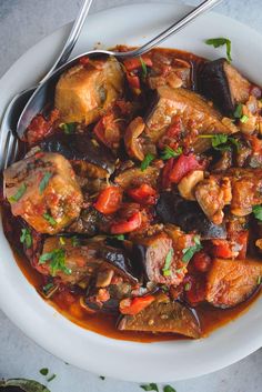 a white bowl filled with meat and vegetables