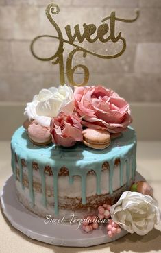 a cake with frosting and flowers on top that says sweet 16 in gold lettering