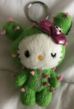 a hello kitty stuffed animal keychain on a bed