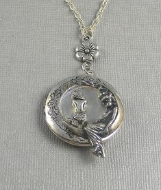 This fantasy inspired locket is 30 inches long. Sterling silver intique platted round locket has beautiful engraved floral patterns on the sides. I have set a tiny cute vintage silver mermaid embellishment in the middle of locket. Next to that is moon Goddess, sitting on the side watching over. Necklace is hanging from antique silver floral link. Pendant is finished with silver chain and silver lobster clasp. Locket is 32mm in size. It has room for two photos inside! Please let me know at checko Moon Locket, Mermaid Locket, Jewelry Locket, Mermaid Moon, Chain Locket, Locket Necklace Vintage, Sea Jewelry, Silver Mermaid, Round Locket