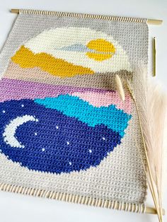 a crocheted placemat with an image of the moon and clouds on it