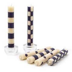 four candles with black and white stripes are lined up next to each other on a table