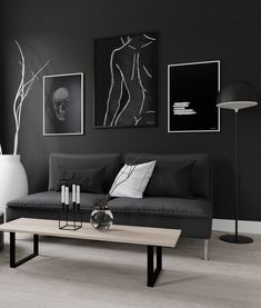 a black and white living room with art on the wall, coffee table and couch