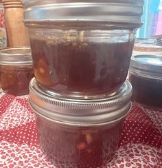 jars filled with food sitting on top of a red and white checkered table cloth