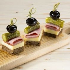 three small sandwiches with olives and ham on them