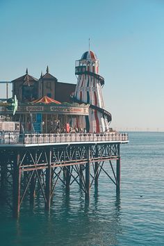 an amusement park sits on the water next to a pier