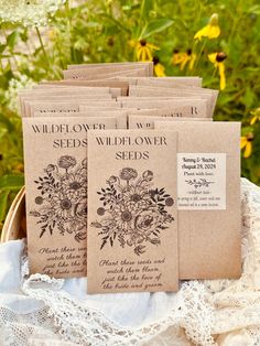 several seed packets sitting on top of a white doily in front of some flowers