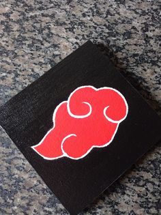 a red and black square shaped object sitting on top of a counter