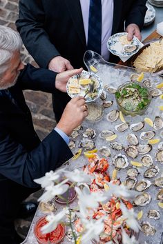 People enjoying raw bar including oysters & seafood Its About Shucking Time Wedding, Oyster Shucking Party, Elegant Party Food Buffet Tables, Oyster Bar Party, Oyster And Champagne Party, Oyster Shucker Wedding, Wedding Oyster Bar, Raw Bar Wedding, Wedding Oysters