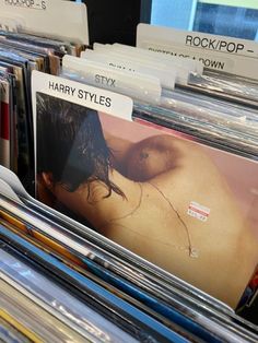 many records are stacked on top of each other in a record store display case,