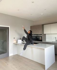 a person jumping in the air on top of a kitchen counter