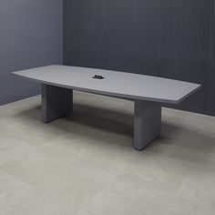 an apple computer sitting on top of a table in front of a gray wall and floor