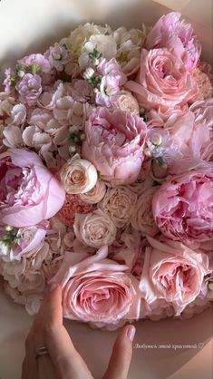 a person holding a bouquet of pink and white flowers