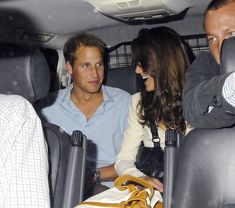 two people sitting in the back seat of a car with one person holding a purse