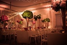 the tables are set with white linens and tall centerpieces filled with pink flowers