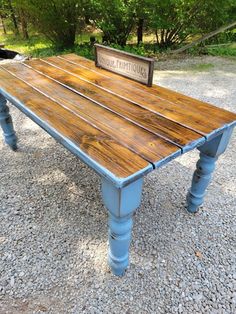 an old wooden table is painted blue and has a sign on it that says antique antiques