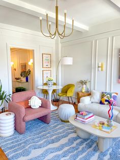 a living room filled with furniture and a chandelier hanging over the top of it