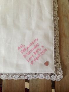 a white handkerchief with pink embroidered hearts on it