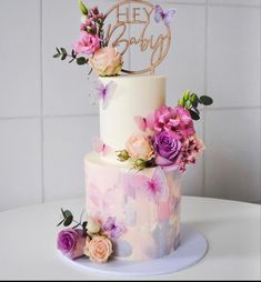 a three tiered cake decorated with pink and purple flowers