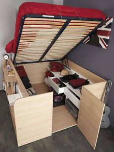 the bed is made up and has two drawers under it, as well as an overhead storage unit