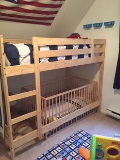 there is a bunk bed in the room with toys on the floor and an american flag hanging above it