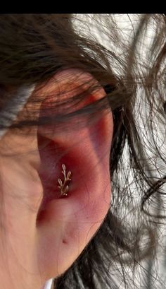 a close up of a person's ear with a tiny flower on it