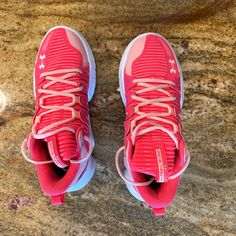 a pair of red shoes sitting on top of a marble floor next to a wall