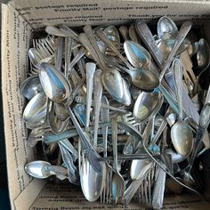 a box filled with lots of silver spoons and forks