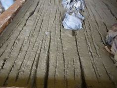 an old wooden floor is covered in dirt and plastic wraps, as seen from above