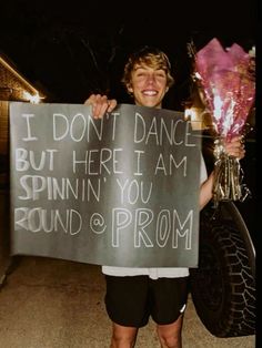 a man holding a sign that says i don't dance but here i am spinning you around and prom