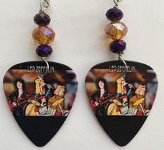 a pair of guitar pick earrings featuring led zepkin and the band's logo