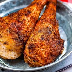 two pieces of chicken sitting on top of a metal plate